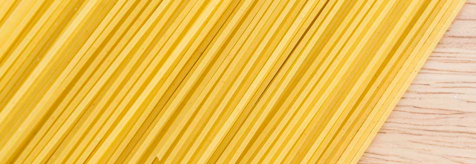 Trenette liegen auf einer Arbeitsplatte aus Holz