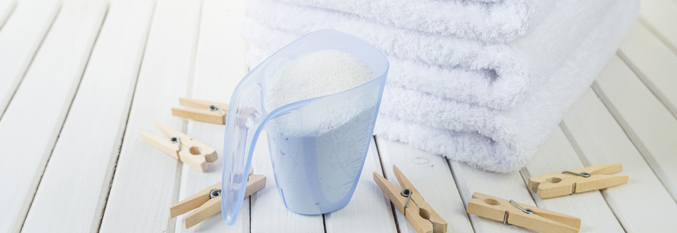 Waschmittel steht vor weißen Handtüchern