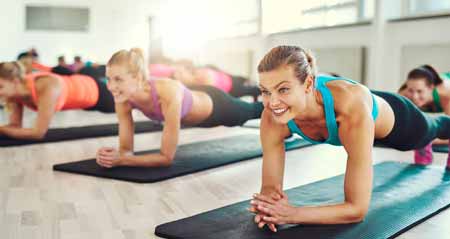 Junge Frauen machen Planking im Fitnessstudio