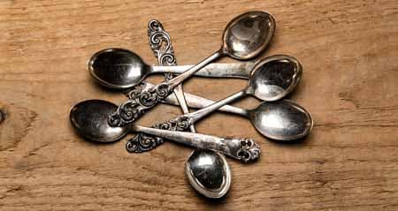Silber reinigen: Silberlöffel liegen auf Holz