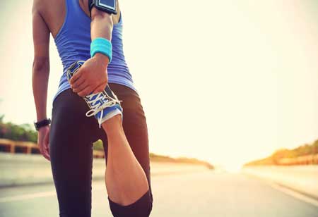 PAYBACK Ratgeber Fitness: Eine junge Frau dehnt die Oberschenkelmuskeln