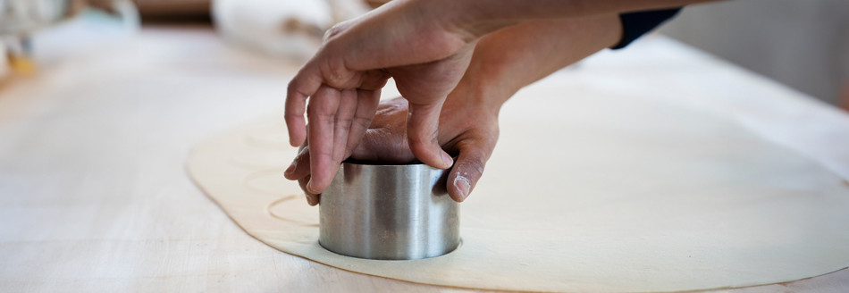 Jemand sticht Kreise aus dem Teig für Culurgiones aus.