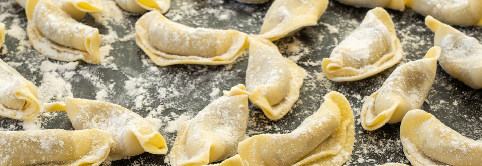 Mehrere Casoncelli liegen kochbereit auf der Arbeitsfläche