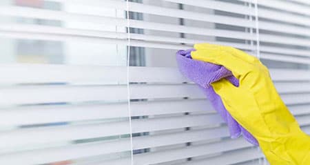 Jalousien reinigen: Jemand reinigt Jalousien