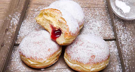 Pfannkuchen bzw. Krapfen auf einem Holzbrett