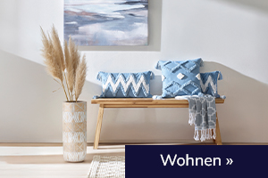 Holzbank mit blauen heine Kissen und Deko. Wohnen.