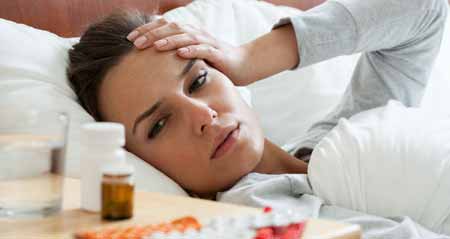 Erkältung vorbeugen: Eine Frau liegt mit Erkältung im Bett