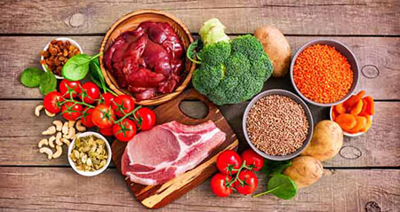 Eisenhaltige Lebensmittel: Verschiedene Nahrungsmittel liegen nebeneinander auf einer Holzfläche