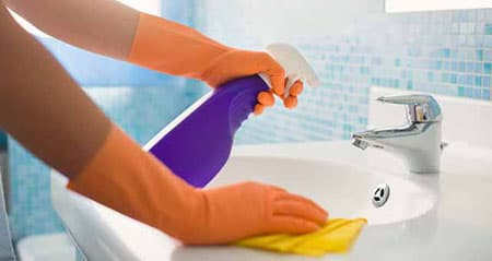 Essig gegen Kalk: Jemand putzt einen Wasserhahn