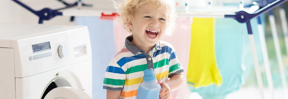 Weichspüler: Ein lachendes Kind hält eine Flasche Weichspüler