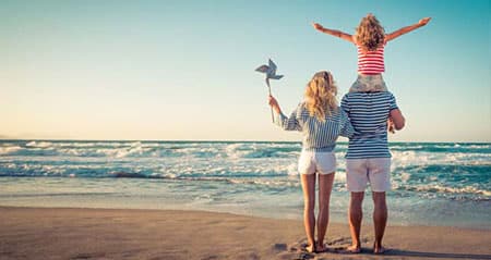 Ferien 2026: Eine Familie freut sich im Urlaub über die Schulferien