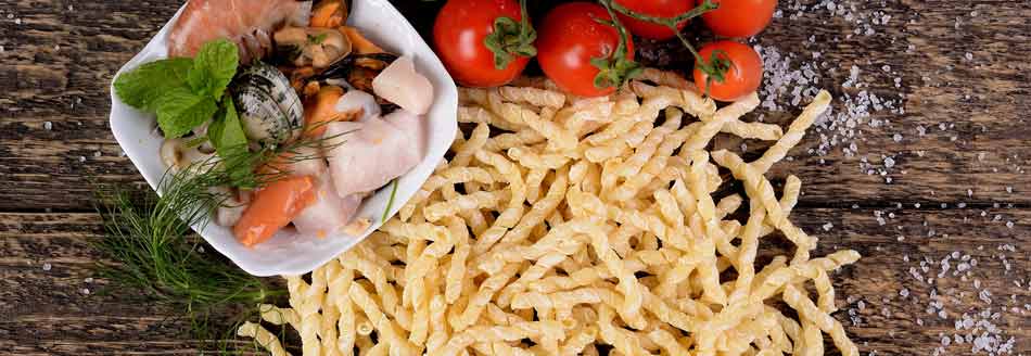 Busiate warten mit Muscheln, Fisch und Tomaten auf ihre Zubereitung