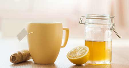 Eine Tasse mit Ingwer, einer Zitrone und Honig