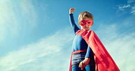 Faschingskostüme selber machen: Ein Junge steht im Superheldenkostüm im Freien