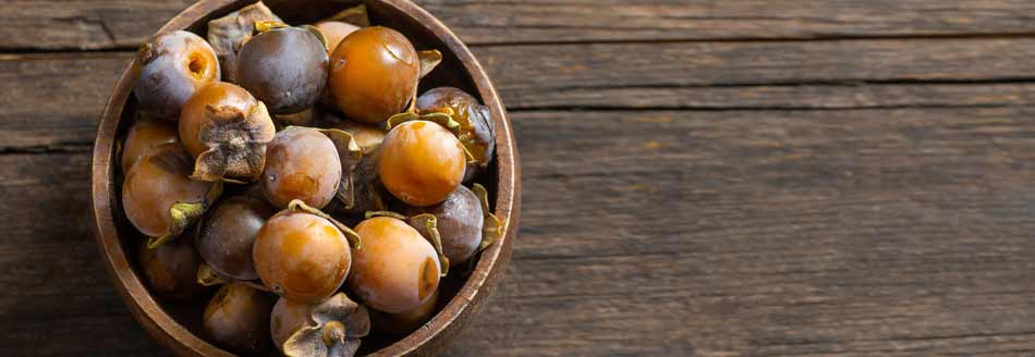 Lotuspflaumen in einer Holzschale
