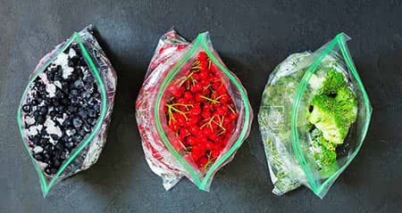 Wie lange ist Gefrorenes haltbar? Drei Tüten mit Tiefkühlware