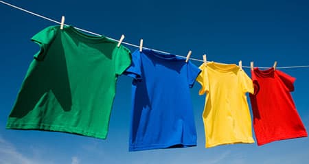 Colorwaschmittel: Kunterbunte T-Shirts hängen auf der Wäscheleine.