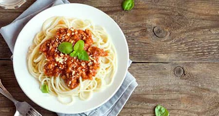 Blitzrezept: Spaghetti Bolognese steht auf einer Holzfläche