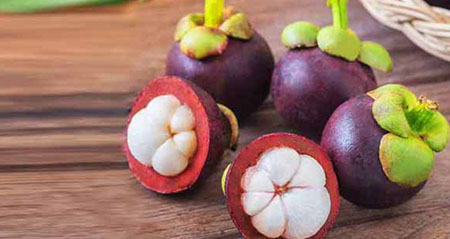 Mangostane-Früchte liegen auf einem Holzbrett