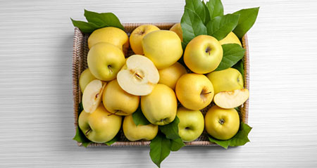 Mehrere Golden Delicious warten in einem Obstkorb auf ihren Verzehr.