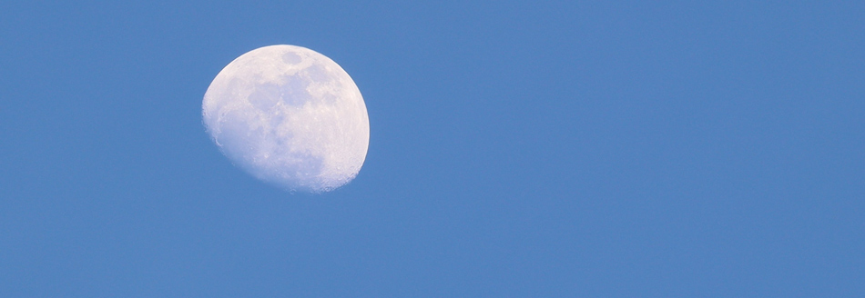 Der Mond ist am herrlich blauen Taghimmel zu sehen.