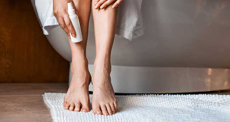 Geschwollene Beine: Eine Frau hält sich den Knöchel