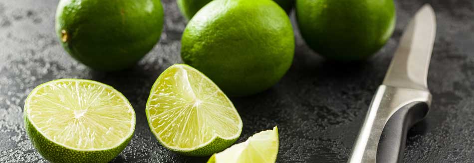 Ganze und aufgeschnittene Limetten warten auf ihren großen Einsatz