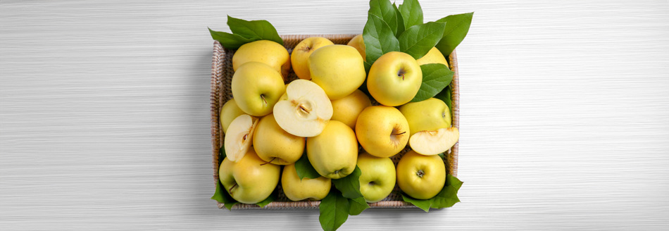 Mehrere Golden Delicious warten in einem Obstkorb auf ihren Verzehr.