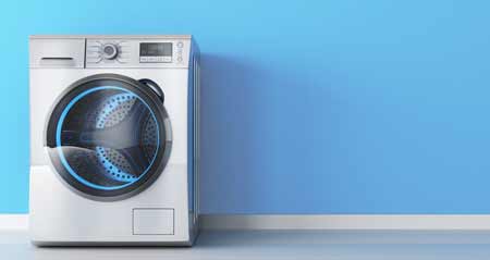 Waschmaschine kaufen: Eine Waschmaschine steht vor einer blauen Wand