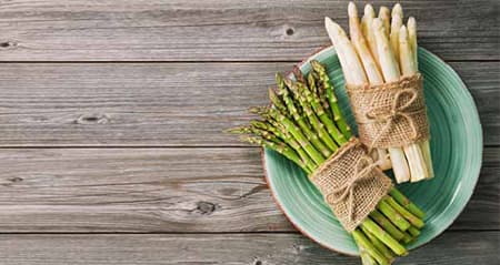 Welcher Spargel ist gesünder? Grüner und weißer Spargel auf einem Teller