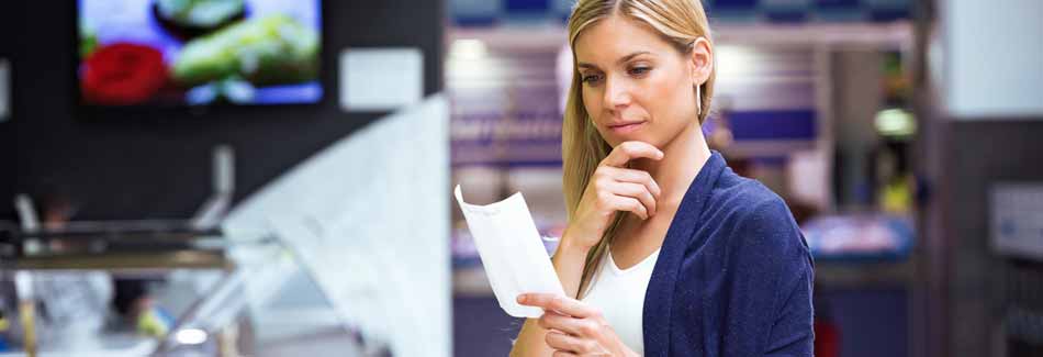 Zeit sparen beim Einkaufen: Eine Frau schaut den Einkaufszettel an