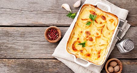 Eine Auflaufform mit herrlichem Kartoffelgratin wartet auf hungrige Genießer.